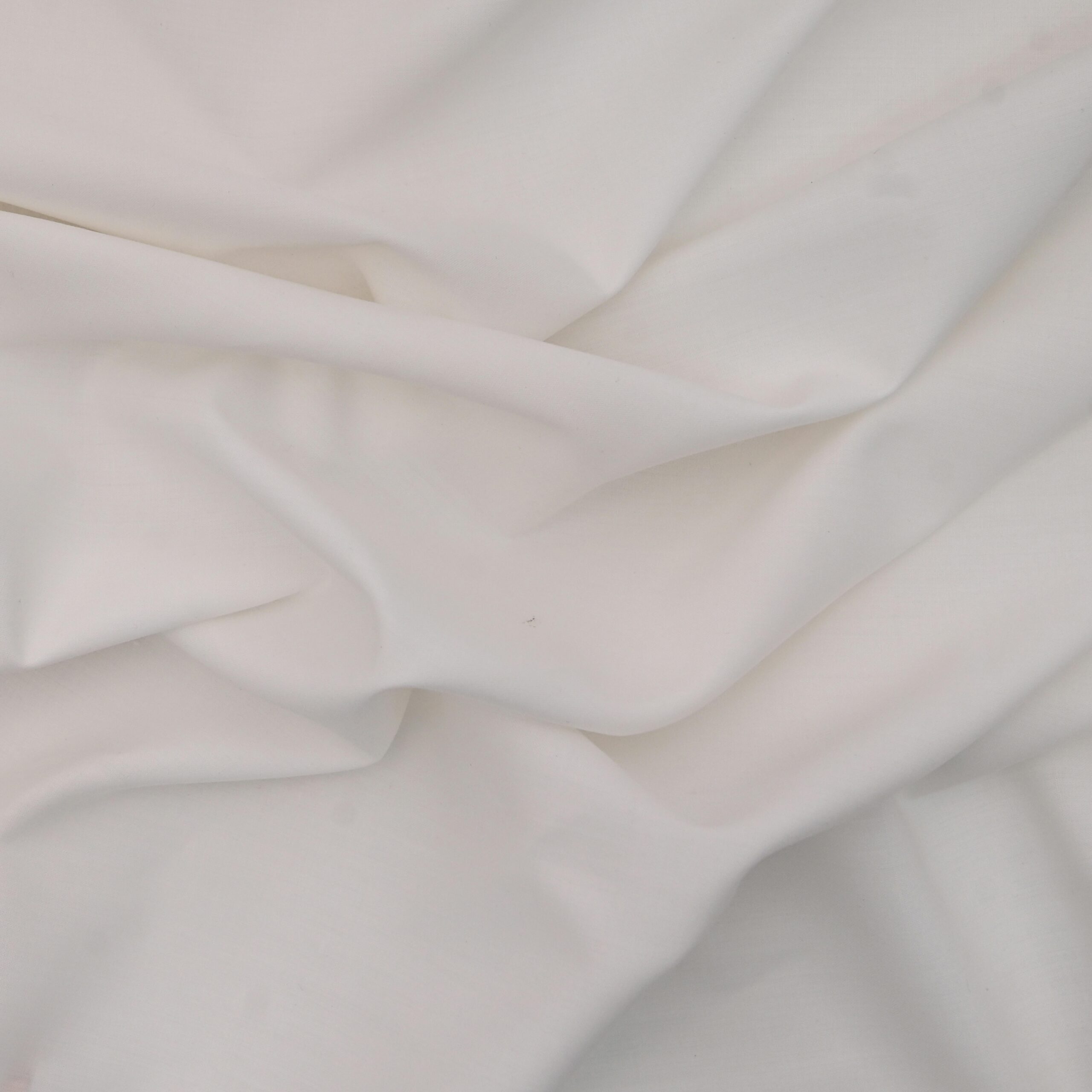 High-resolution image of a white fabric showcasing elegant draping and soft folds.